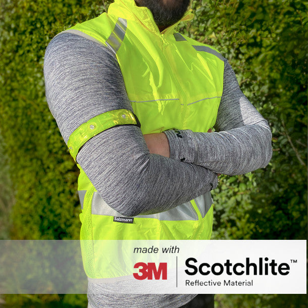 Person standing outside wearing yellow cycling vest and LED band 