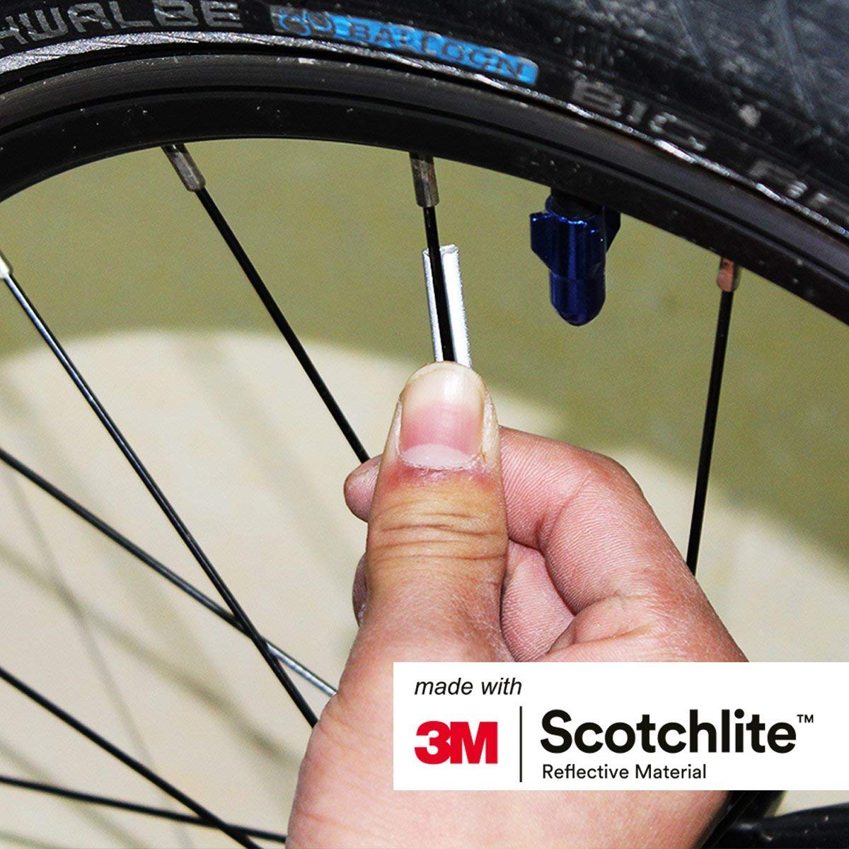 close up image of person attaching spoke reflector to spoke. 