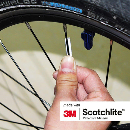 close up image of person attaching spoke reflector to spoke. 