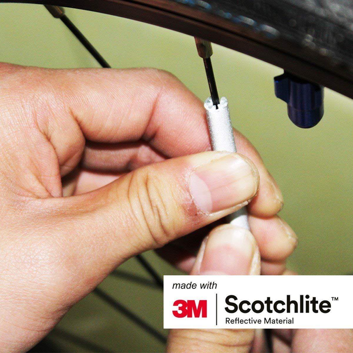 Close up image of person attaching spoke reflector to spoke. 